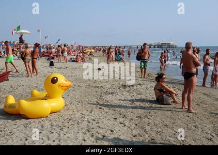 Versilia, Italia. 22 agosto 2021. La gente si aggetta sulla riva in Versilia, Toscana, Italia, il 22 agosto 2021. La Toscana ha più di 400 km (250 miglia) di costa. La parte settentrionale di essa, denominata Versilia, ha un'ampia e lunga spiaggia di sabbia che va per chilometri da Marina di Carrara a Torre del Lago Puccini, punteggiando località di fascino come Forte dei Marmi, Marina di Pietrasanta, Viareggio. Centinaia di stabilimenti balneari coprono il mare, con le Alpi Apuane, una catena di montagne molto impressionante, sullo sfondo.(Photo by Elisa Gestri/Sipa USA) Credit: Sipa USA/Alamy Live News Foto Stock