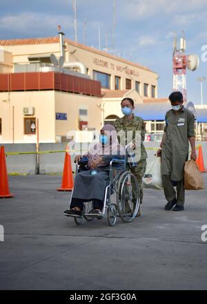 Sigonella, Italia. 22 agosto 2021. US Navy Senior Airman Romero assiste gli evacuati quando sbarcano da un aereo della U.S. Air Force C-17 Globemaster III dopo l'arrivo alla Naval Air Station di Sigonella il 22 agosto 2021 a Sigonella, Italia. NAS Sigonella fornisce alloggio temporaneo per gli evacuati dall'Afghanistan come parte dell'operazione Rifugi Alleati. Credit: Planetpix/Alamy Live News Foto Stock