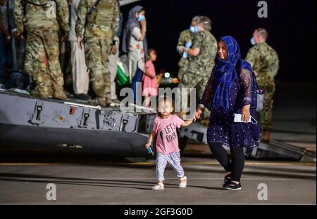 Sigonella, Italia. 22 agosto 2021. Le famiglie afghane evacuate da Kabul sbarcano un aereo della forza aerea statunitense C-17 Globemaster III dopo l'arrivo alla Stazione aeronavale di Sigonella il 22 agosto 2021 a Sigonella, Italia. NAS Sigonella fornisce alloggio temporaneo per gli evacuati dall'Afghanistan come parte dell'operazione Rifugi Alleati. Credit: Planetpix/Alamy Live News Foto Stock