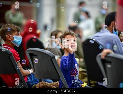 Sigonella, Italia. 22 agosto 2021. Un ragazzo afghano evacuato da Kabul, gioca con le bolle dopo l'arrivo alla Stazione aeronavale di Sigonella il 22 agosto 2021 a Sigonella, Italia. NAS Sigonella fornisce alloggio temporaneo per gli evacuati dall'Afghanistan come parte dell'operazione Rifugi Alleati. Credit: Planetpix/Alamy Live News Foto Stock