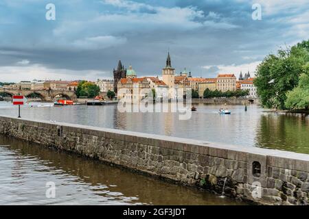 Praga, Repubblica Ceca-Agosto 4,2021. Turisti che attraversano il fiume Moldava su pedalò e divertirsi, Ponte Carlo in background.River crociera Foto Stock