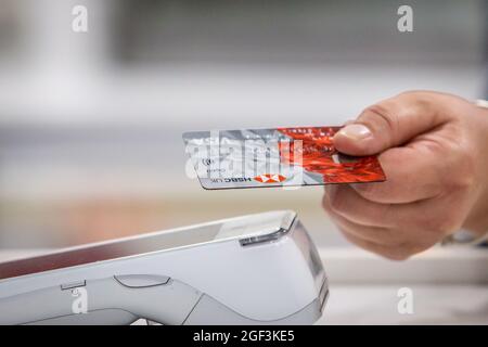 Primo piano di una carta di debito bancaria utilizzata per l'acquisto tramite contactless. Foto Stock