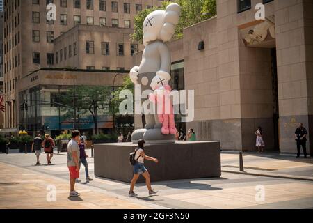 I visitatori del Rockefeller Plaza vedono la "CONDIVISIONE" dell'artista KAWS esposta come parte dell'arte pubblica del Rockefeller Center, vista mercoledì 11 agosto 2021. La scultura in bronzo alta 18 metri, che mostra motivi di carattere cartoon utilizzati dall'artista, sarà in mostra fino a ottobre. (© Richard B. Levine) Foto Stock