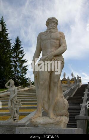 Inquadratura ad angolo basso di una statua in pietra bianca sulla scala del Palazzo Peterhof, San Pietroburgo Foto Stock