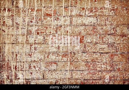 Vecchio muro di mattoni sporchi con vernice peeling. Foto Stock
