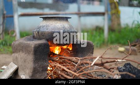 Stufa di campagna indiana di cottura di terra all'aperto o stufa di creta di Chulha o di creta con un vaso circolare di colore nero su esso, Foto Stock