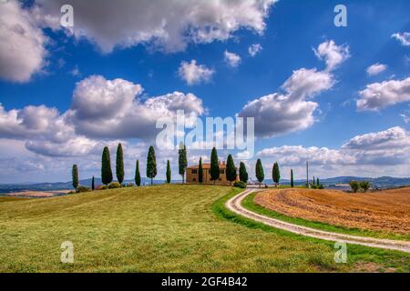 Toscana, Italia - Luglio 6, 2018: cipressi e prato con tipica casa toscana, Val d'Orcia, Italia - Toscana Foto Stock