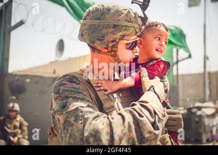 La Marina degli Stati Uniti con la 24a unità Marine Expeditionary (MEU) calma un bambino piangente durante un'evacuazione all'Aeroporto Internazionale Hamid Karzai, Afghanistan, 22 agosto. I membri del servizio degli Stati Uniti stanno assistendo il Dipartimento di Stato con un'operazione di evacuazione non combattente (NEO) in Afghanistan. (STATI UNITI Foto del corpo marino di staff Sgt. Victor Mancilla via American PhotoArchive/Alamy) Foto Stock