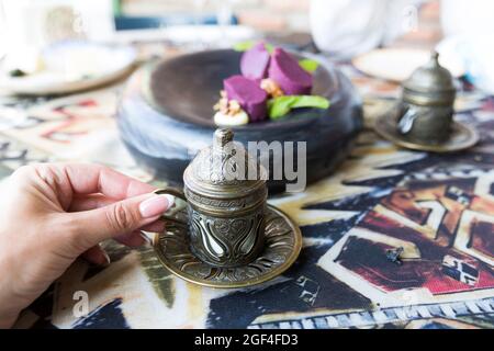Caffè orientale in tradizionale caffettiera di rame con fiori sul davanzale  della finestra. Davanzale in legno con tulipani arancioni e vaso di fiori  di giacinto. Pioggia fredda Foto stock - Alamy