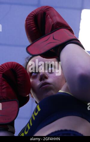 Ritratto di una giovane ragazza con guanti rossi allenamento boxe in palestra Foto Stock