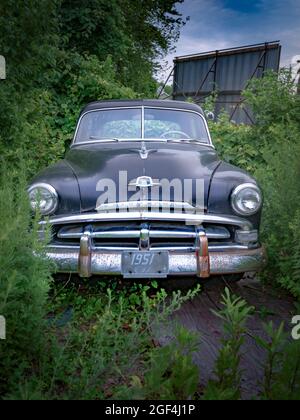 Westbrook, USA - 23 luglio 2017: Vintage 1951 Plymouth project car abbandonata e cresciuta sul retro del lotto aspetta di essere adottata. Foto Stock