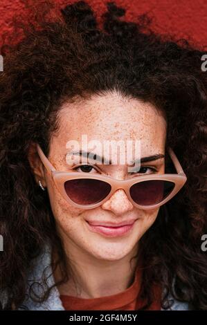 Bella ragazza sorridente che indossa occhiali da sole Foto Stock