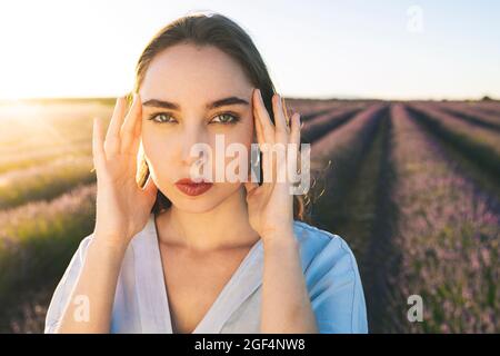 Giovane donna con testa in mano sul campo di lavanda Foto Stock