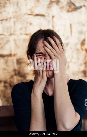 Donna frustrato che copre il viso con le mani Foto Stock