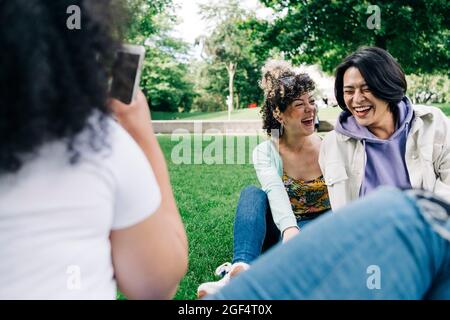 Felici amici maschili e femminili al parco pubblico Foto Stock