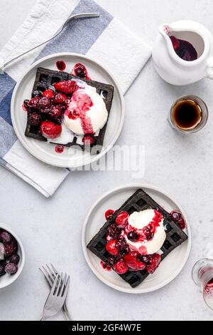 Waffle freschi al cioccolato con gelato e salsa di fragole Foto Stock