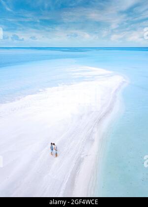 Vista aerea di giovani coppie in piedi insieme sulla spiaggia costiera sabbiosa dell'isola di Thulusdhoo Foto Stock