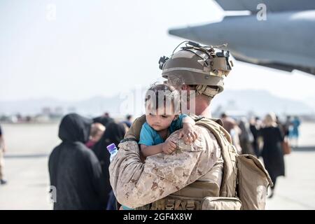 Una Marina con Special Purpose Marine Air-Ground Task Force-Crisis Response-Central Command (SPMAGTF-CR-CC) calma un bambino durante un'evacuazione all'Aeroporto Internazionale Hamid Karzai, Kabul, Afghanistan, 21 agosto 2021. I membri del servizio USA stanno assistendo il Dipartimento di Stato con un prelievo ordinato di personale designato in Afghanistan. Credito obbligatorio: Samuel Ruiz/US Marine Corps via CNP Foto Stock