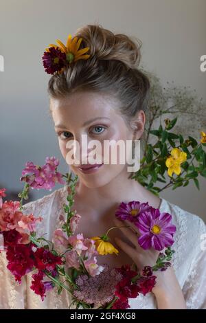 Giovane donna con fiori di campo multicolore in studio Foto Stock