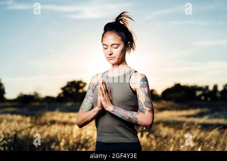 Donna meditating mentre fa yoga in campagna Foto Stock