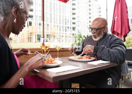 La coppia mangia insieme mentre si siede al ristorante Foto Stock