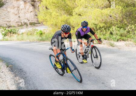 Atleti di sesso maschile che cavalcano biciclette su strada Foto Stock