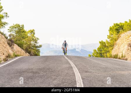 Atleta maschile maturo in bicicletta su strada Foto Stock