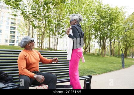 Donna sorridente che mostra abbigliamento all'uomo Foto Stock