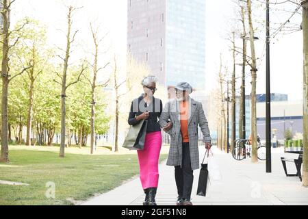 Coppia con borse shopping a piedi sul sentiero in città Foto Stock