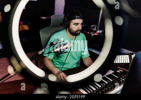 DJ professionista che suona sintetizzatore mentre compone musica in studio Foto Stock