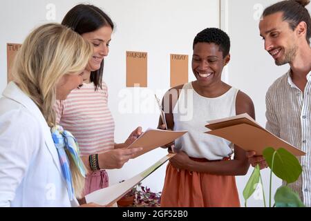 Il team aziendale creativo controlla i documenti mentre lavora in ufficio Foto Stock