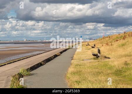 Wallasey, Regno Unito: Percorso ciclabile e argine lungo il North Wirral Coastal Park, guardando in lontananza verso i moli di Liverpool. Foto Stock