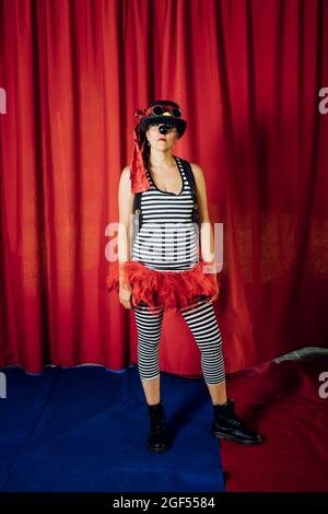 Clown femminile con cappello e costume in piedi sul palco Foto Stock