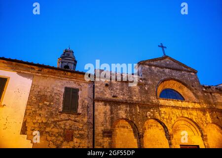 Italia, Provincia di Pisa, Pomarance, antiche mura della Chiesa di San Giovanni Battista al crepuscolo Foto Stock