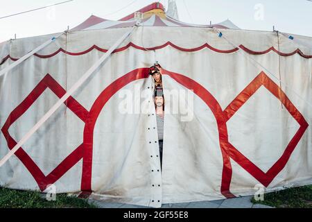 Artisti del Circo che scavano attraverso l'ingresso della tenda del circo Foto Stock