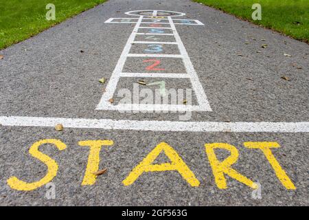 Figura disegnata per un gioco per bambini - hopscotch su una strada asfaltata Foto Stock