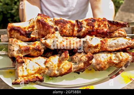 Donna che tiene kebab fritti cotti. I pezzi succosi di carne sono Bravo. Foto Stock