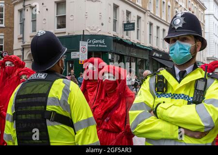 Londra, Regno Unito. 23 Agosto 2021. I membri della ribellione dell'estinzione hanno visto affrontare la ribellione rossa con gli ufficiali di polizia durante il giorno della ribellione dell'estinzione una di due settimane di dimostrazione nel centro di Londra.la ribellione dell'estinzione ha tenuto una protesta contro il cambiamento climatico, il riscaldamento globale, Che prevede di affrontare la causa alla radice della crisi climatica ed ecologica e di chiedere al governo di cedere dalle società di combustibili fossili prima della COP26 Conferenza delle Nazioni Unite sul cambiamento climatico del 2021. (Foto di Dave Rushen/SOPA Images/Sipa USA) Credit: Sipa USA/Alamy Live News Foto Stock