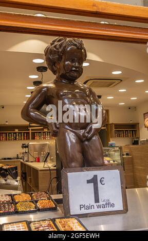 Bruxelles, Belgio - 31 luglio 2021: Primo piano della statua gigante di cioccolato Manneken Pis alla finestra aperta del negozio che vende cialde e cioccolatini. Foto Stock