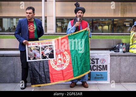 Londra, Regno Unito. 23 Agosto 2021. I manifestanti detengono una bandiera afghana durante la manifestazione. In seguito alla recente presa della capitale afghana Kabul da parte dei talebani, la diaspora afghana a Londra si è riunita al di fuori dell'ufficio nazionale per esprimere solidarietà a quella afghana. Chiedevano un'azione urgente da parte del governo di Boris Johnson per proteggere i familiari le cui vite sono minacciate, in particolare mettendo in luce i diritti delle donne e dei bambini. Credit: SOPA Images Limited/Alamy Live News Foto Stock