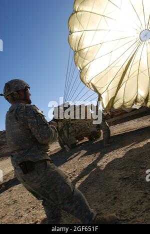 Esercito Sgt. Mike Fogleman, un capo squadra mortaio della sede centrale e della sede centrale della Società, 1° Battaglione (Airborne) 503° Fanteria, 173° Brigata Airborne, lotta per impedire a un paracadute di soffiare via dopo essere stato staccato dalle forniture che ha portato a terra nella provincia di Paktika, Afghanistan, 9 novembre. Fogleman è di Locust Grove, OK. Foto Stock