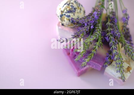 Sapone lavanda e bombe da bagno, rametti di lavanda. Concetto di cosmetici vegan eco-friendly. Cosmetici vegetali biologici con estratto di lavanda Foto Stock