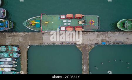 Vista aerea di una grande nave e gruppo di phinisi tradizionali nel porto di Labuan Bajo. Foto Stock