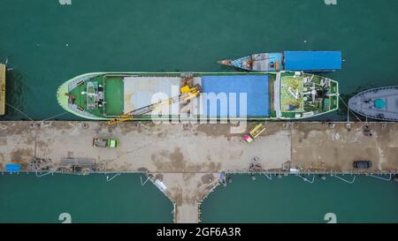 Vista aerea di una grande nave e gruppo di phinisi tradizionali nel porto di Labuan Bajo. Foto Stock