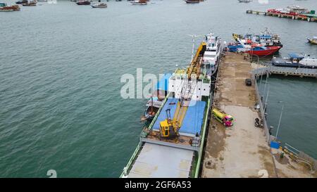 Vista aerea di una grande nave e gruppo di phinisi tradizionali nel porto di Labuan Bajo. Foto Stock