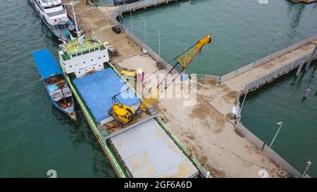 Vista aerea di una grande nave e gruppo di phinisi tradizionali nel porto di Labuan Bajo. Foto Stock