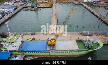 Vista aerea di una grande nave e gruppo di phinisi tradizionali nel porto di Labuan Bajo. Foto Stock