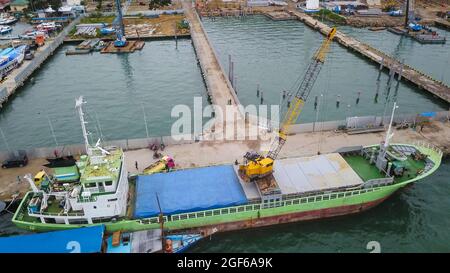 Vista aerea di una grande nave e gruppo di phinisi tradizionali nel porto di Labuan Bajo. Foto Stock