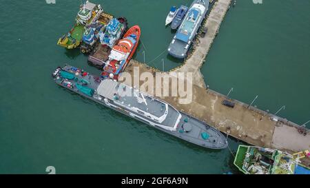 Vista aerea di una grande nave e gruppo di phinisi tradizionali nel porto di Labuan Bajo. Foto Stock