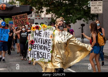 Washington, DC, USA, 23 Agosto, 2021. Nella foto: Uno dei centinaia di dimostranti indossa un mantello d'oro protestando contro il gasdotto Enbridge Line 3 durante una dimostrazione sponsorizzata da Shut Down DC e Extinction Rebellion. Il gasdotto passa attraverso le terre del trattato e le sorgenti del fiume Mississippi per trasportare l'olio di sabbie bituminose dal Canada. I suoi impatti ecologici e climatici nei prossimi 50 anni saranno paragonabili alla costruzione e al funzionamento di 50 centrali elettriche a carbone. Credit: Allison Bailey / Alamy Live News Foto Stock